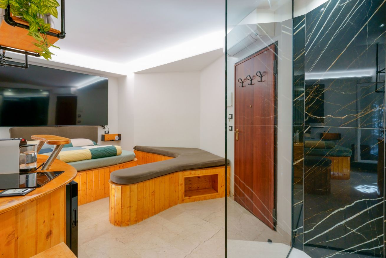 Luxury spa privata con vasca idromassaggio in legno, doccia walk-in marmorizzata e arredi raffinati per il massimo relax.