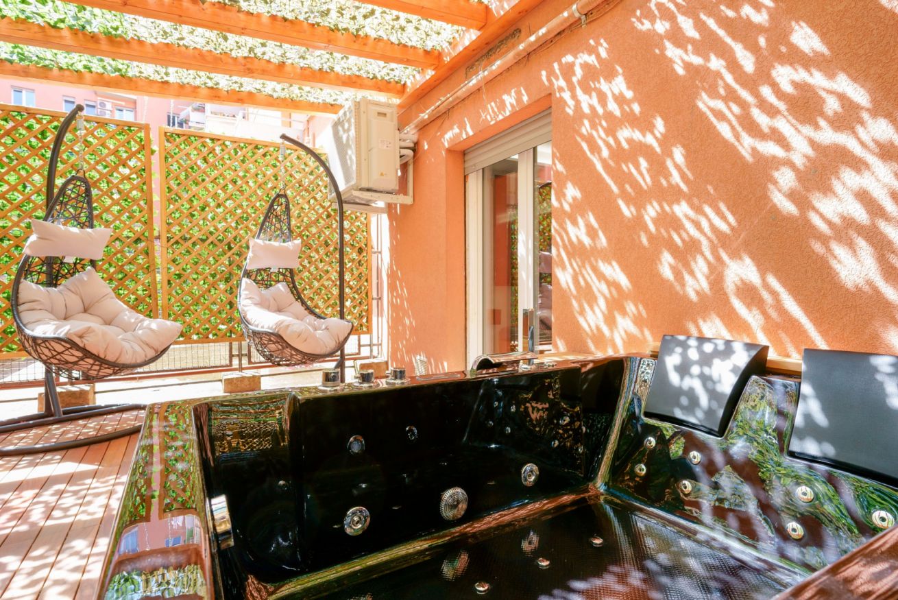 Terrazza esclusiva con amache sospese e vista sulla corte interna, perfetta per momenti di relax sotto il sole della Sicilia.