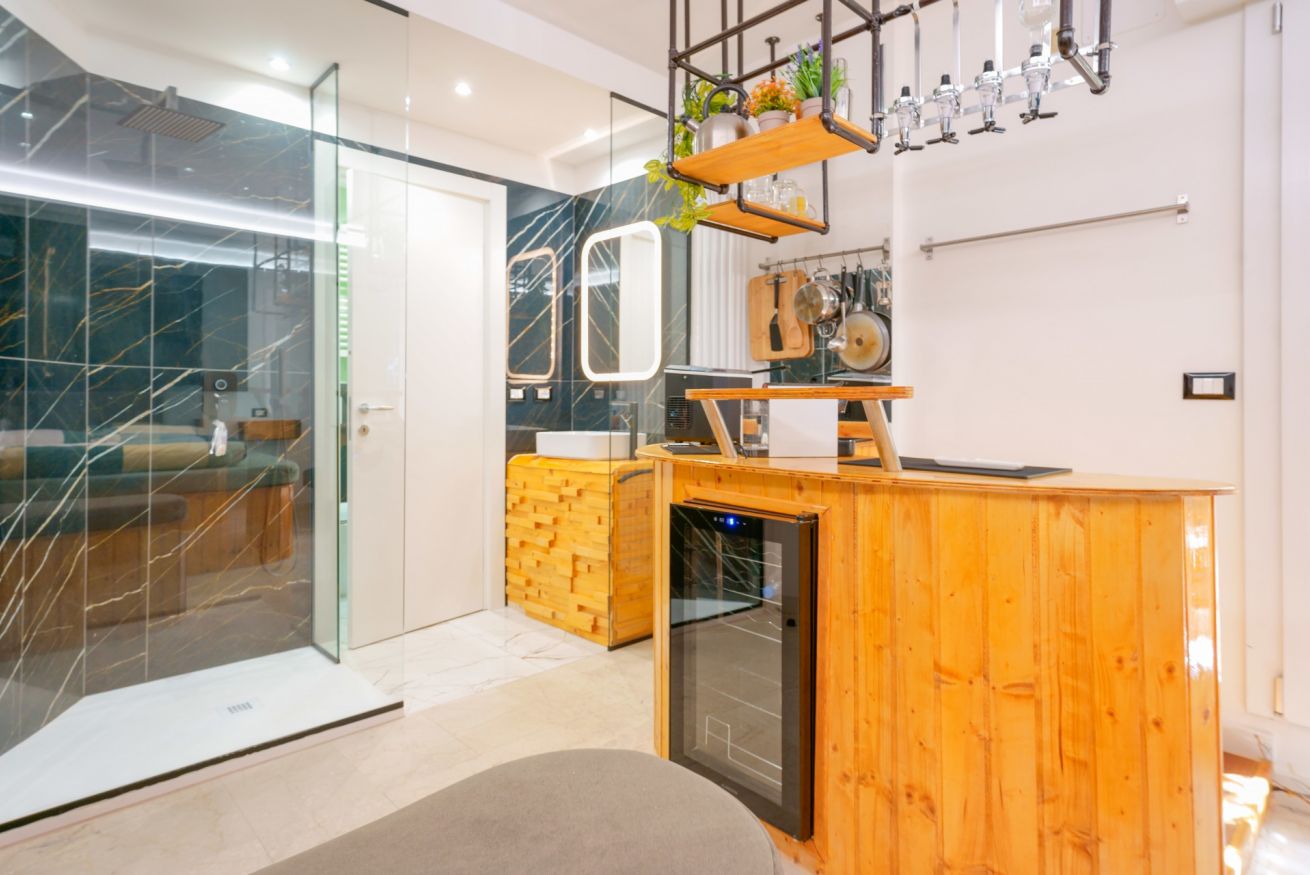 Bagno elegante con arredo in legno naturale, specchio illuminato e accessi moderni che riflettono il comfort della Deluxe Amendola 17.