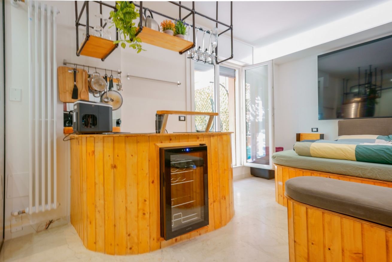 Elegante zona living con arredamento in legno naturale, minibar integrato e accesso alla terrazza, perfetto per il vostro relax.