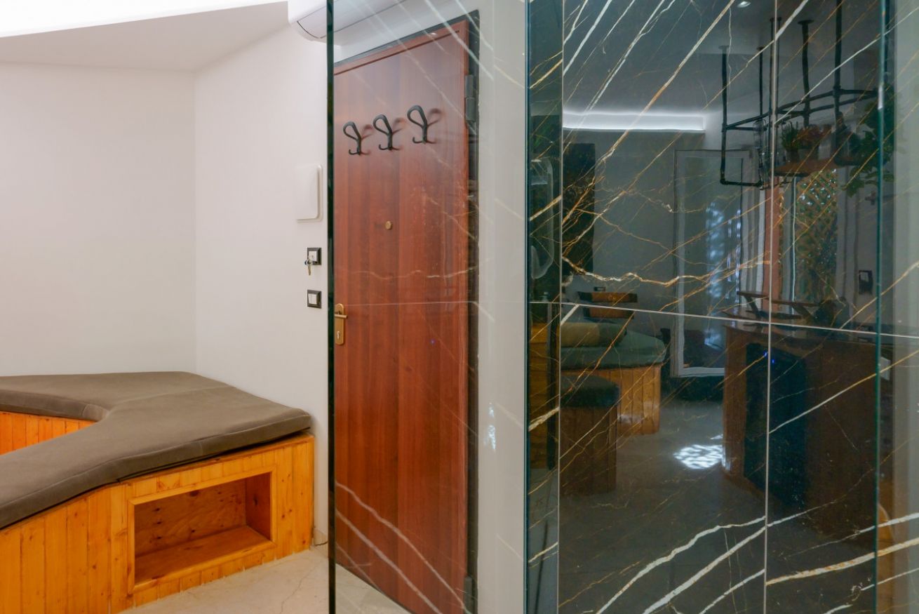 Elegante ingresso con dettagli in legno e vetrate geometriche, che introduce agli spazi raffinati della camera matrimoniale deluxe.