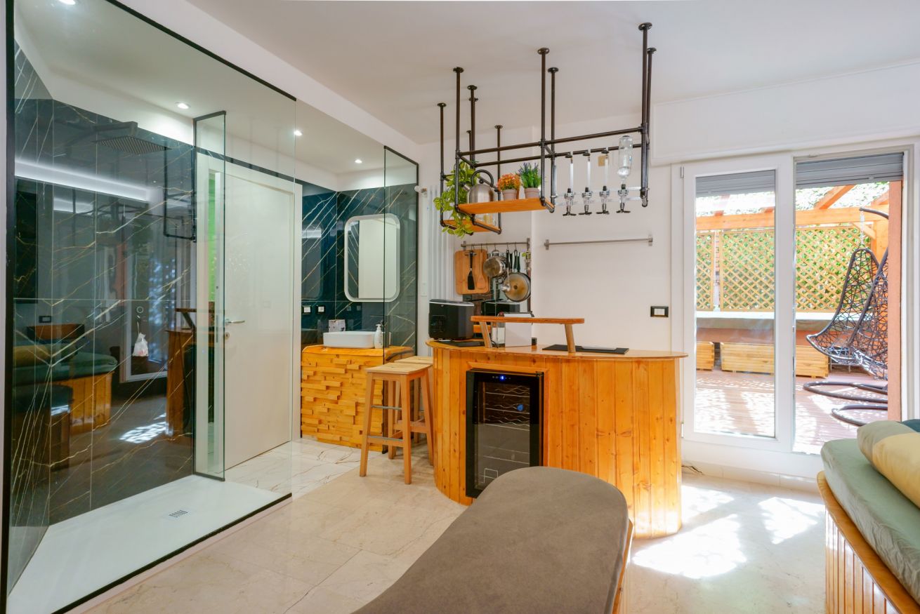 Bagno lussuoso con vanity in legno, doccia walk-in e accesso diretto alla terrazza privata, perfetto rifugio di relax.