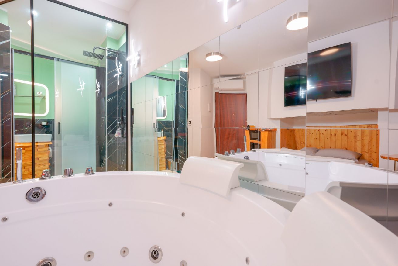 Lussuosa camera matrimoniale con vasca idromassaggio a 2 posti, doccia walk-in e arredamento moderno che promette relax e benessere.