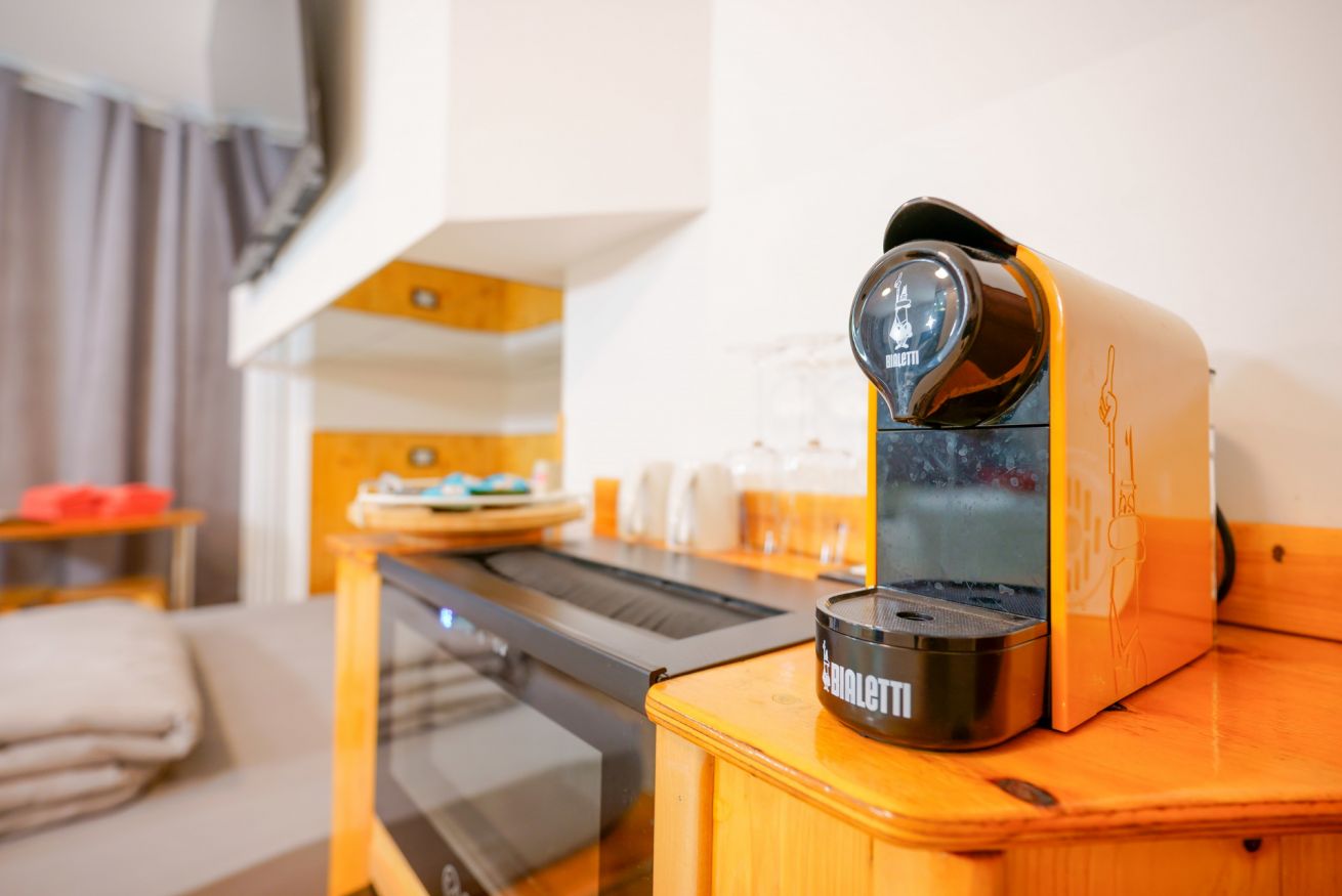 Camera elegante con tocchi di design contemporaneo: la macchina del caffè Nespresso orange vi accoglie per iniziare la giornata con stile.
